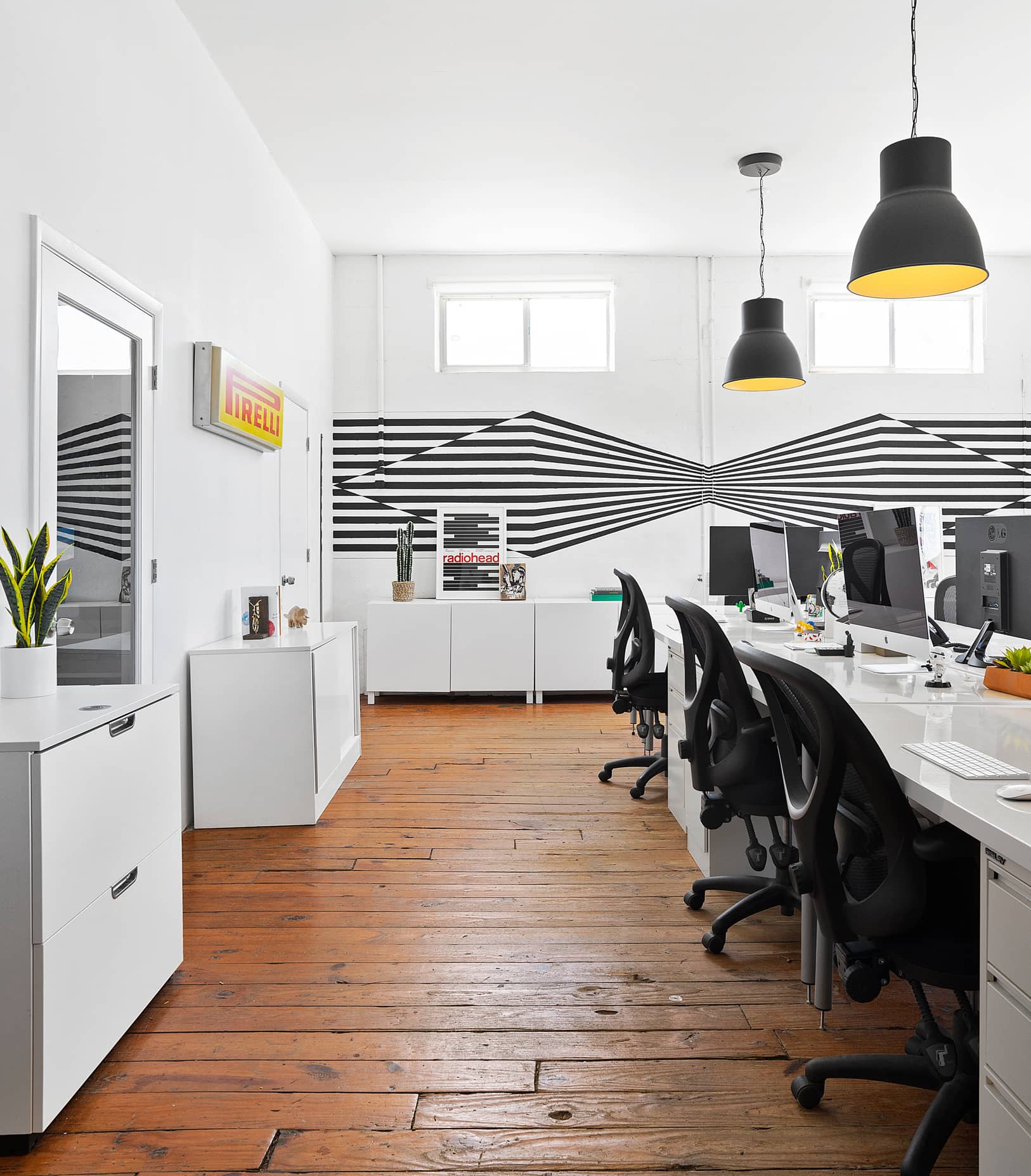 Studio workstations area with artistic paintings on back wall | Think Twice studio